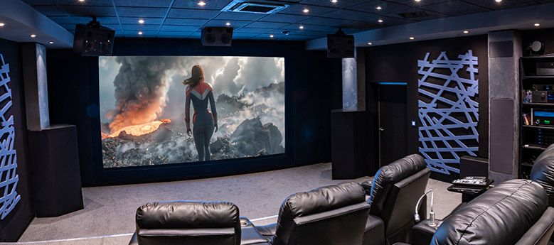 Heimkino-Vorführraum mit großer Leinwand und Kinosesseln